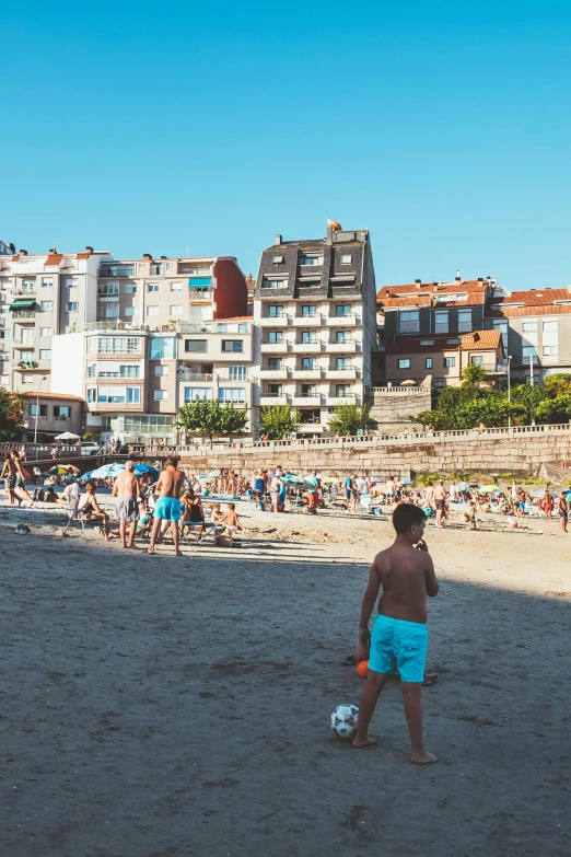 man walking on beach towards els and other crowded beach