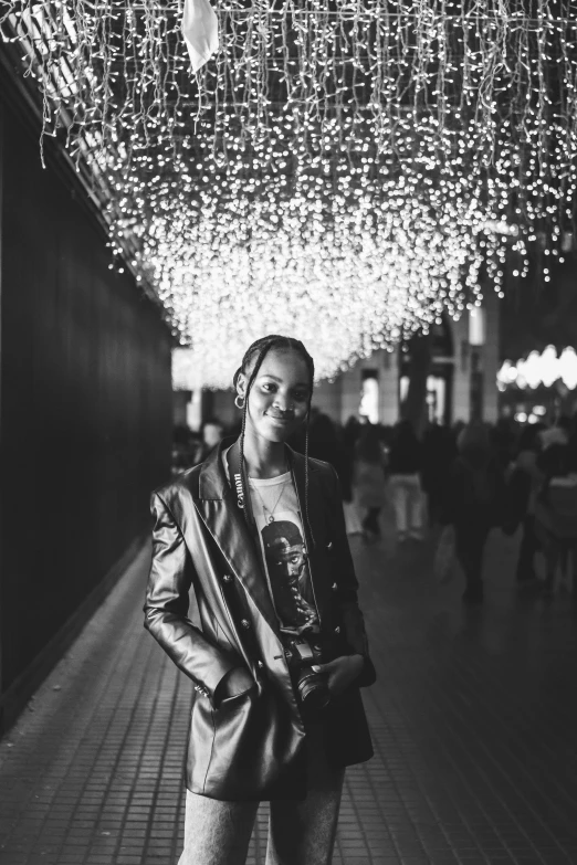 black and white pograph of a woman standing under lights