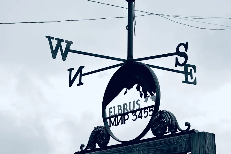 a weather vane that has been fashioned to look like a business sign