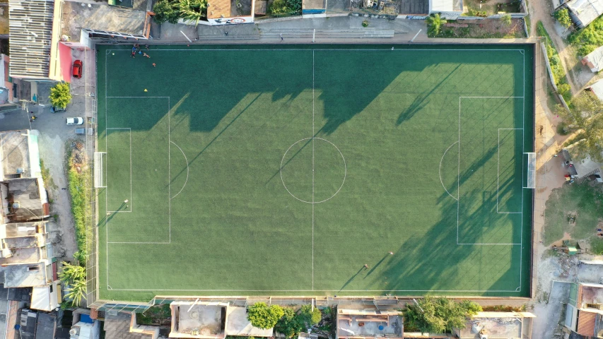 an aerial view of a soccer field, with lots of houses surrounding