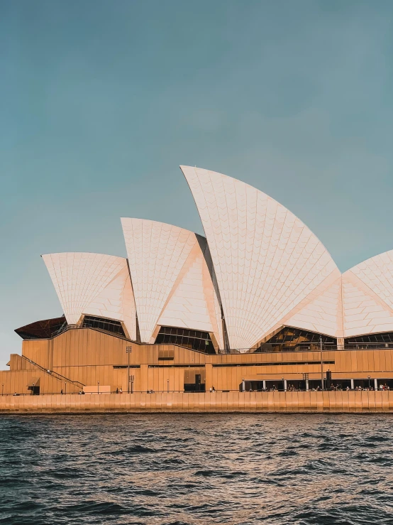 an opera with sails in the water near it