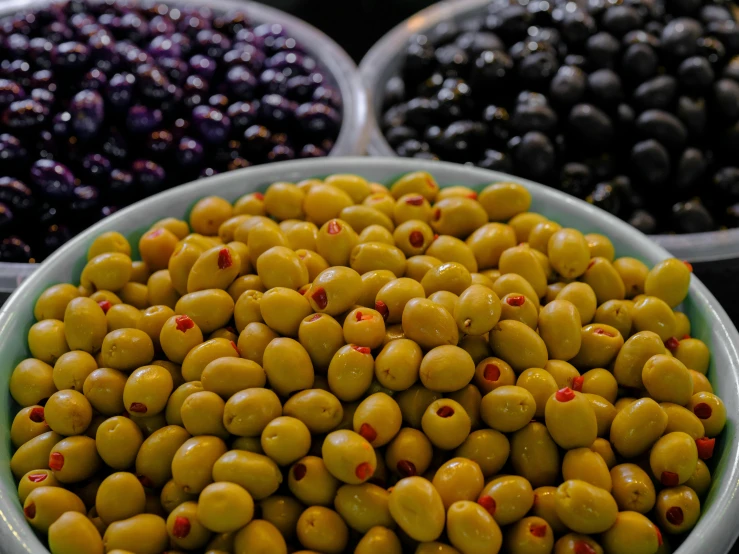 close up of olives and other fruits in bowls