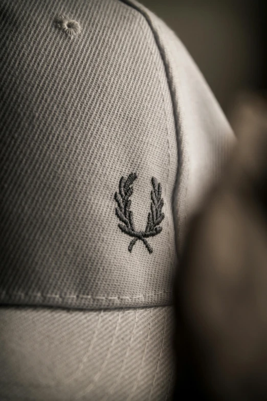 a cap that has a laurel and cross design