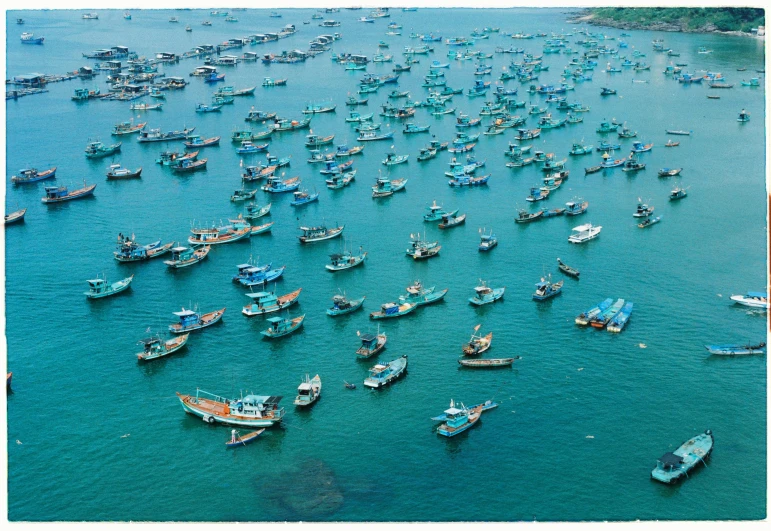 a group of boats in the ocean surrounded by smaller boats