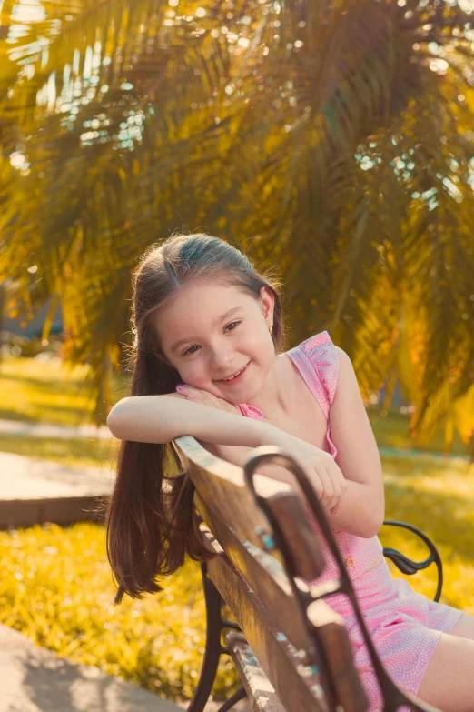 a girl smiles as she sits on a park bench