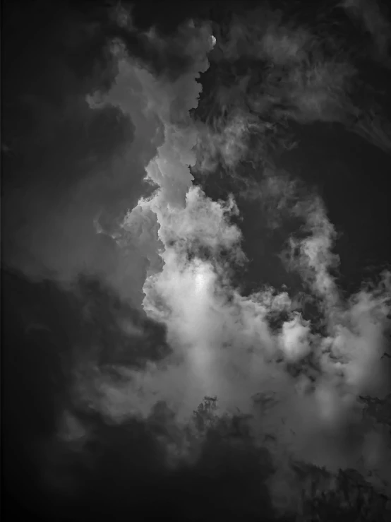 some clouds are in the sky in black and white