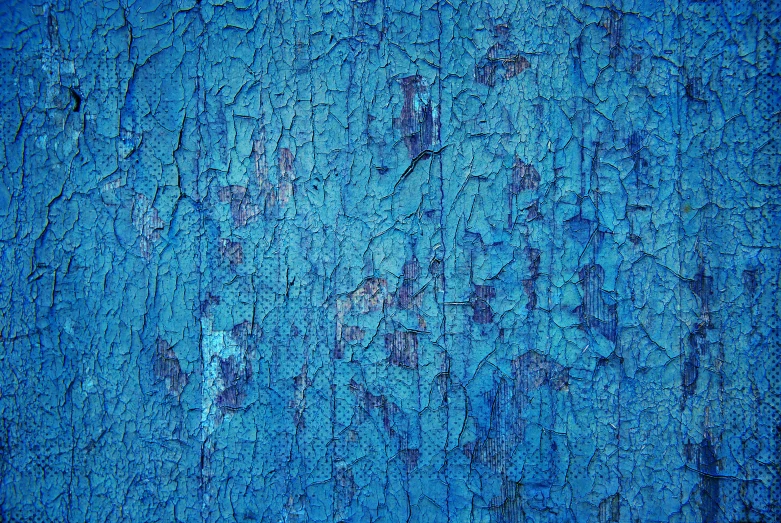 a blue and black wall with chipped paint