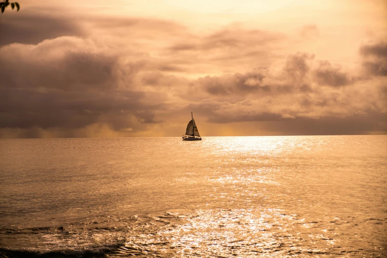 the sailboat floats across the water on cloudy day