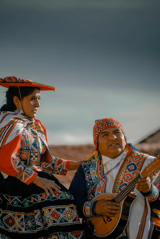 two women with their instruments sitting on a hill