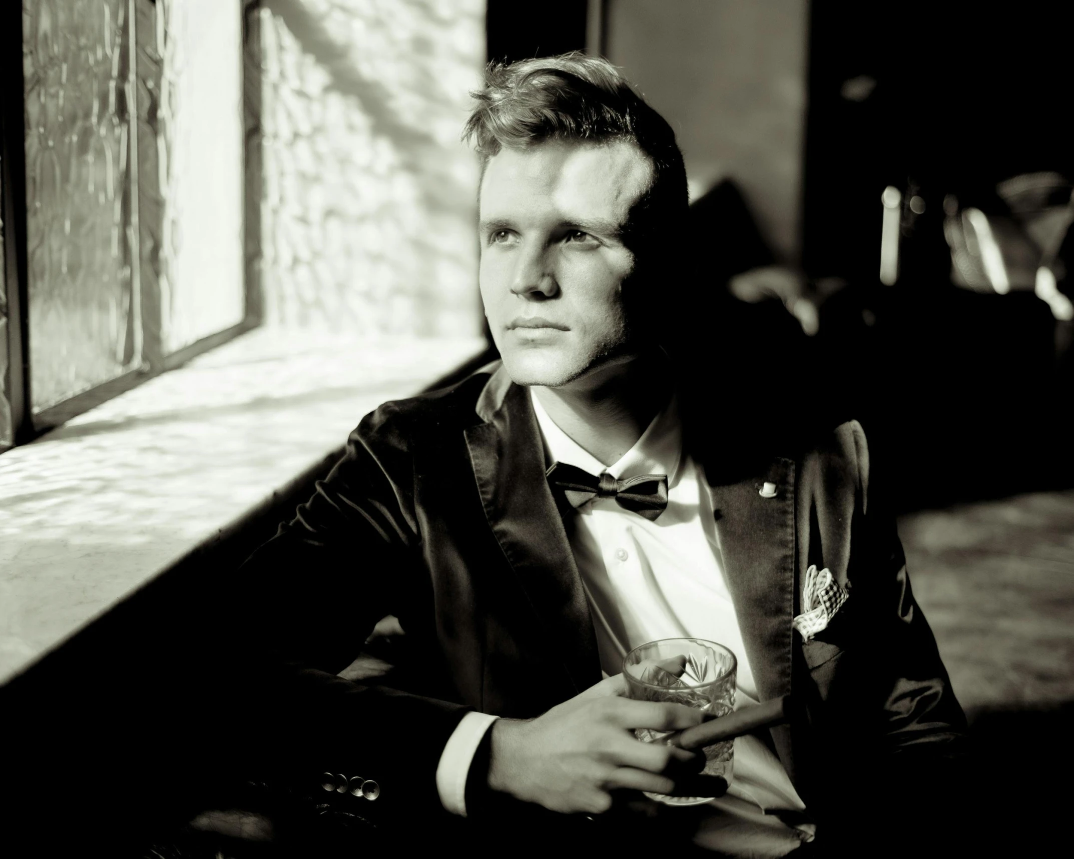 black and white image of a man in tuxedo looking off into the distance