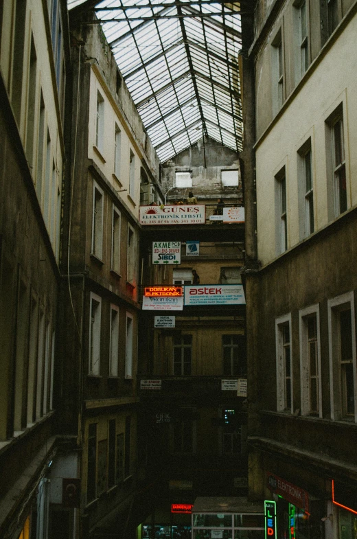 a narrow courtyard is filled with signs and a roof