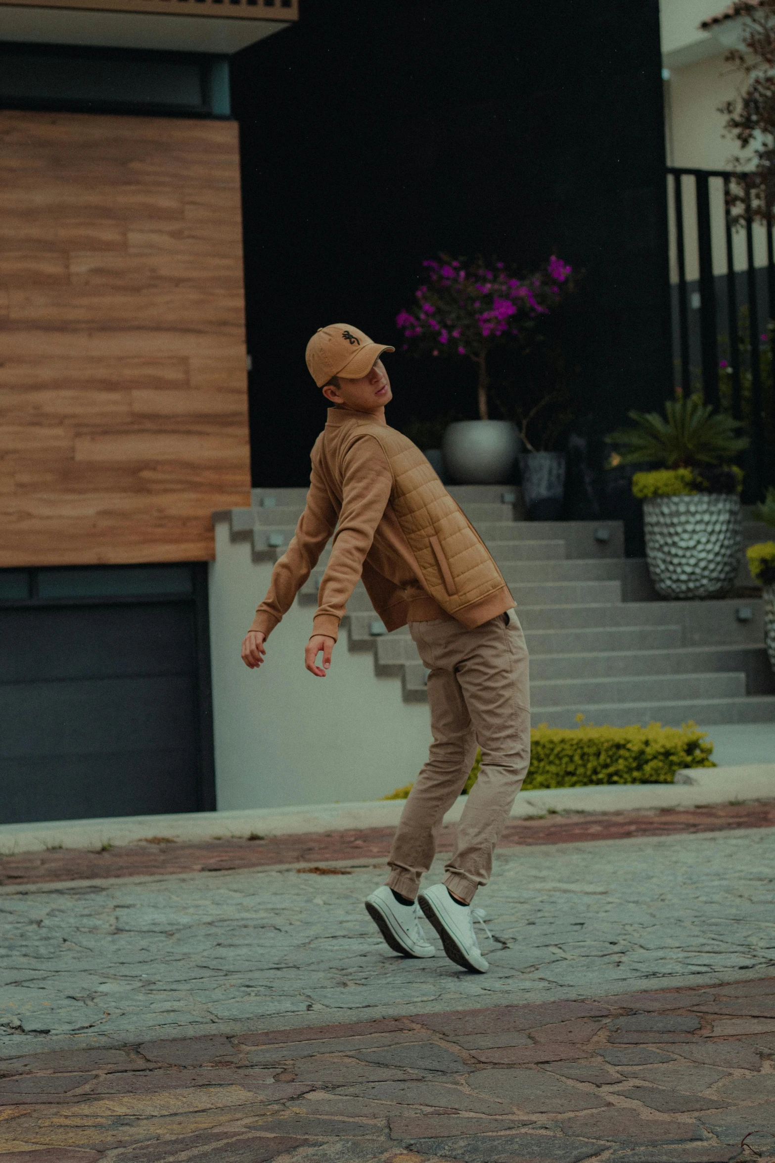 a young man riding a skateboard on top of a sidewalk