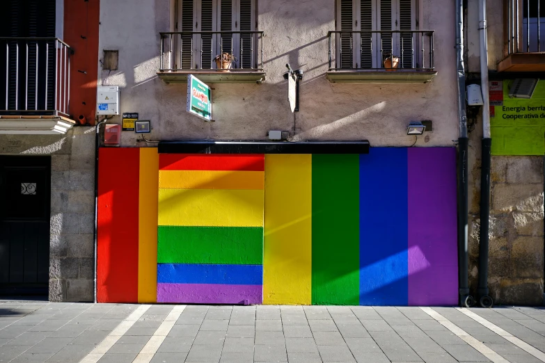 a rainbow colored door in an alley way