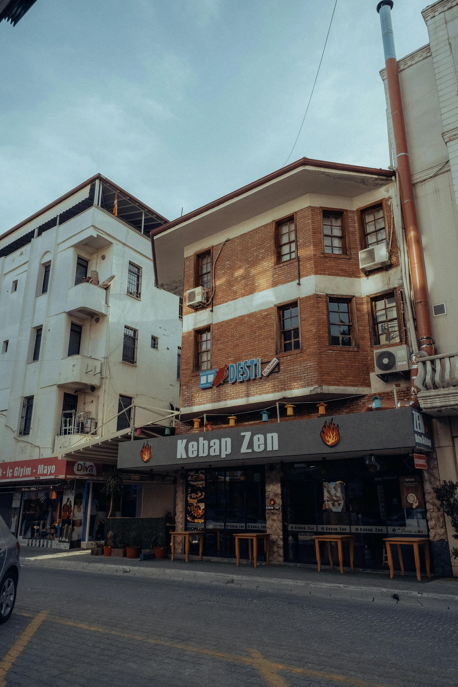 an old building on the corner of a street in front of some tall buildings