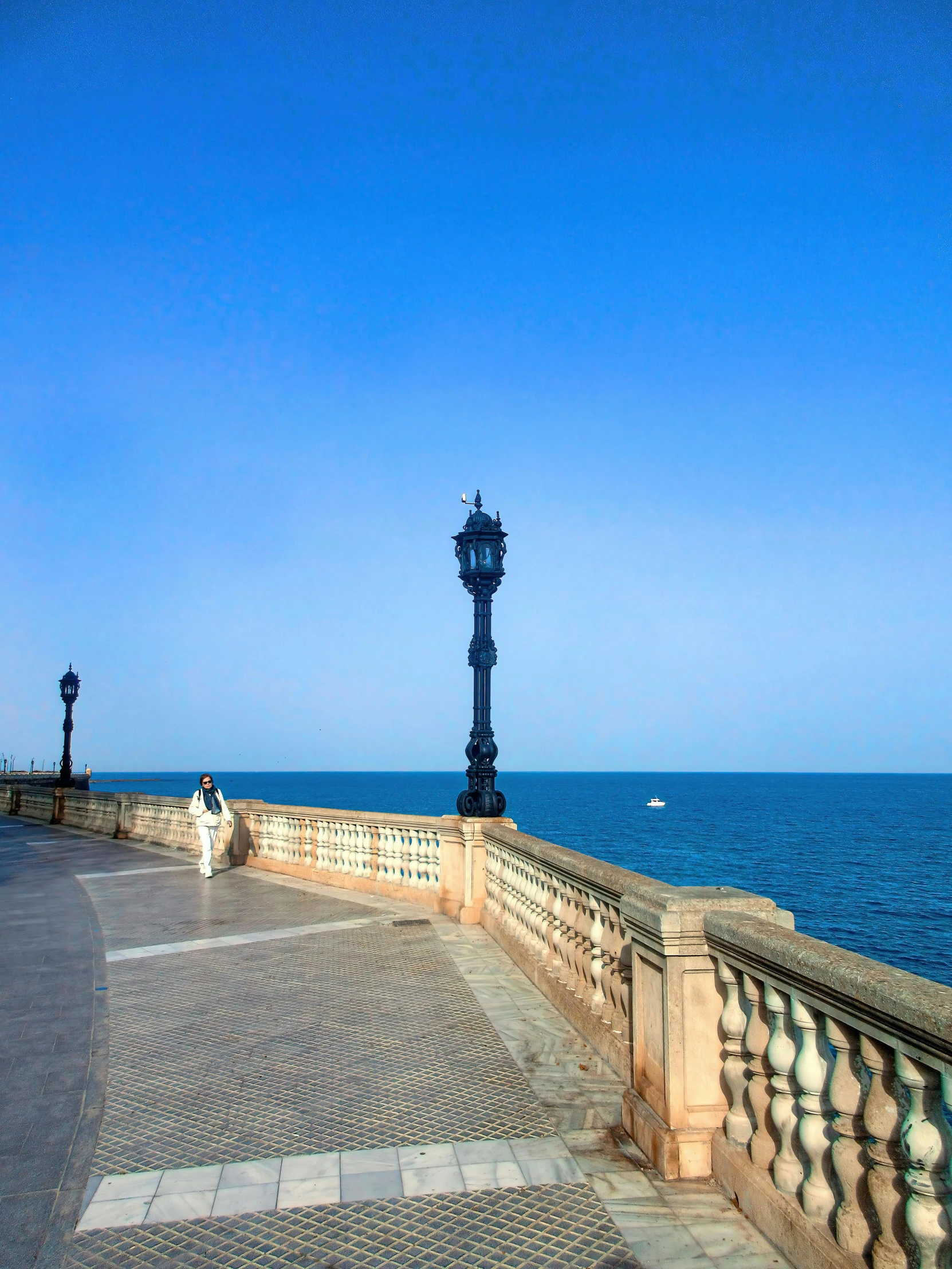 there is a clock tower sitting on the sea wall