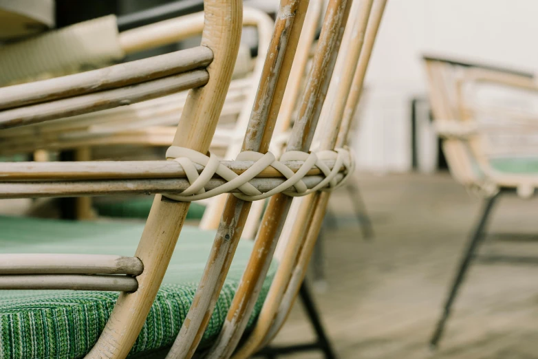 a close up of a set of wooden chairs with green cushioning