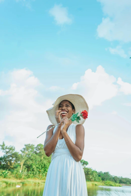 a woman wearing a white dress and straw hat smiling