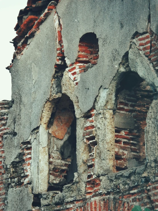 old brick and cement crumbling up a wall