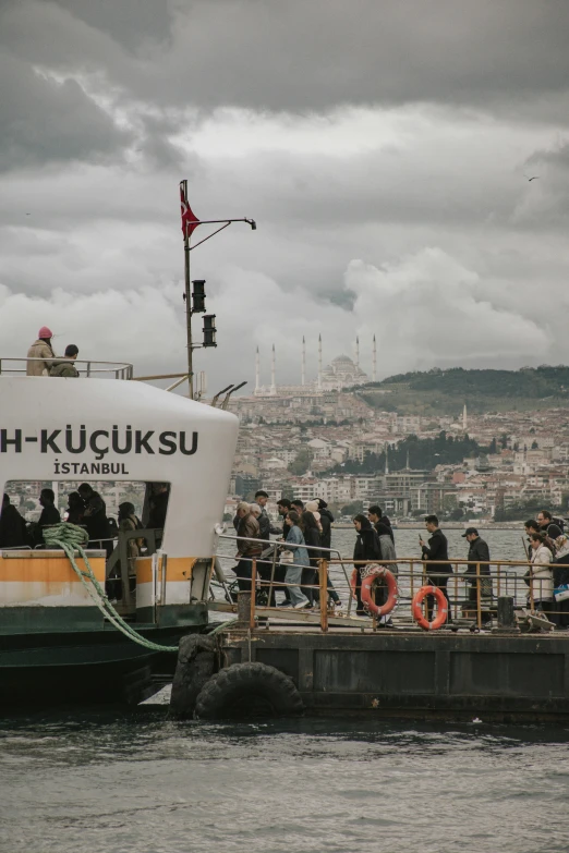 many people are boarding a boat from a harbor