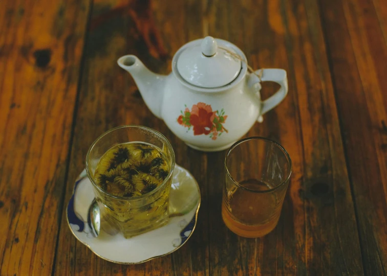 a tea pot and a glass on a plate