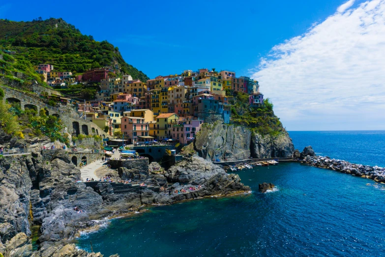 there is a small group of buildings that are on the cliff next to the water