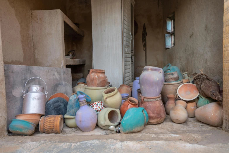 a pile of old, colorful pottery outside of a building