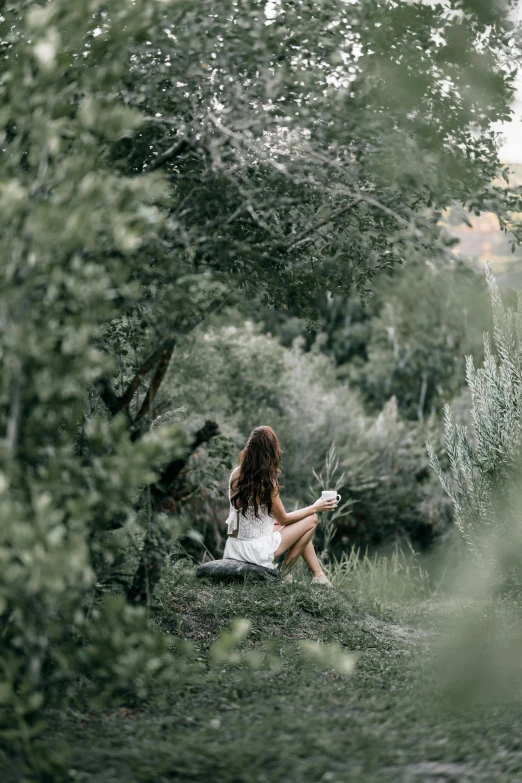 the woman is sitting on the grass outside