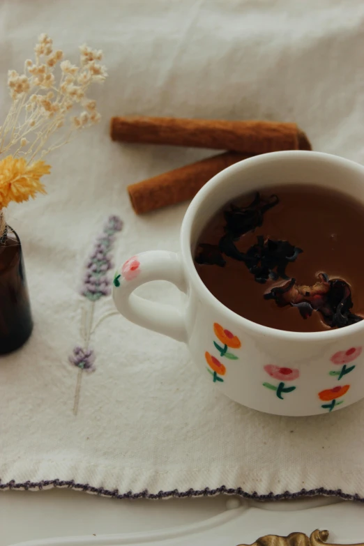 the mug of tea has some cinnamon sticks on it