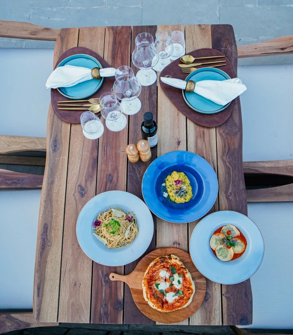 an overhead view shows a wooden table that is decorated with various dishes of food