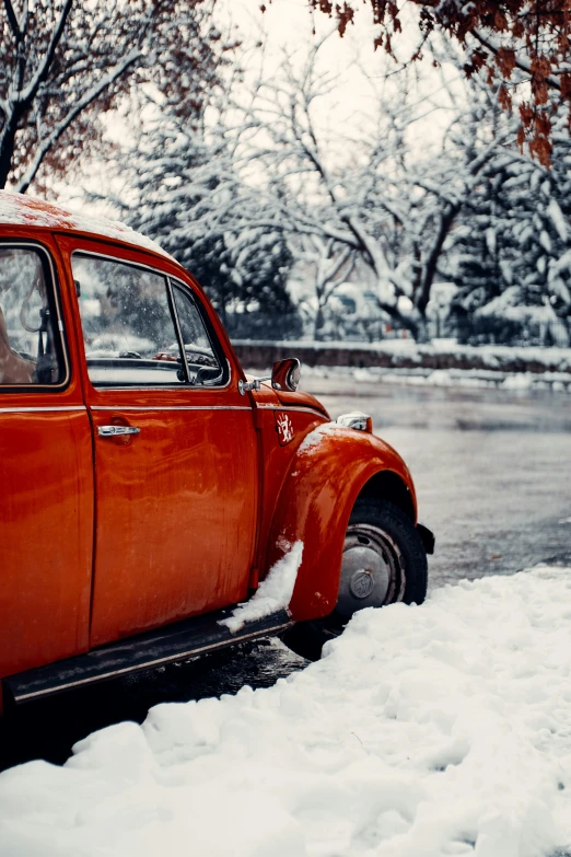 an old orange truck parked in the snow