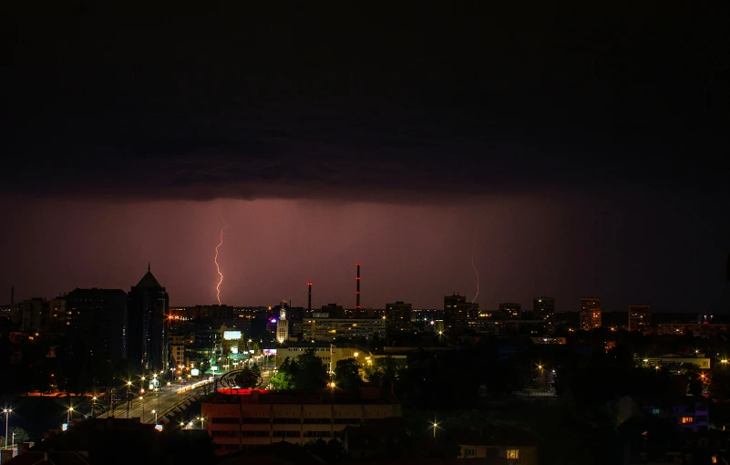 a city skyline with skyscrs and street lights under a lightning - filled sky