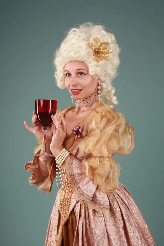woman in a pink dress holding a glass of wine