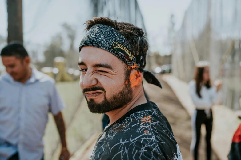 two men standing next to each other while wearing bandanas