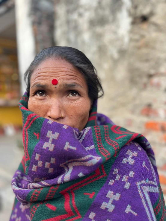 the woman in the colorful scarf is covering her face