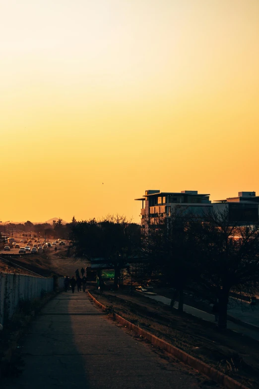 the sun is setting over a city street