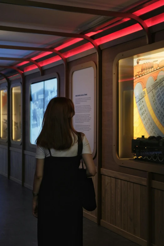 the woman has a suitcase on her back while walking through the museum