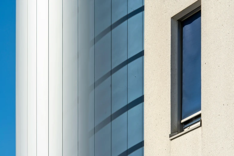 a wall with a window on one side and a curtain on the other side