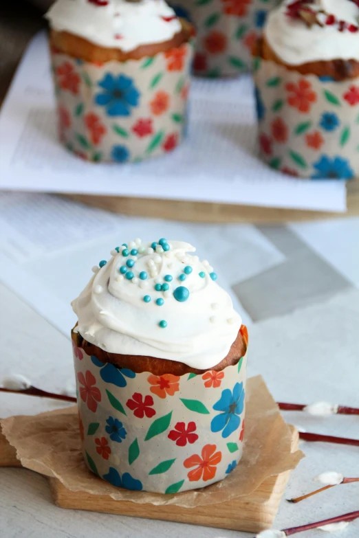 a muffin with a white frosting on top and decorated with blue sprinkles