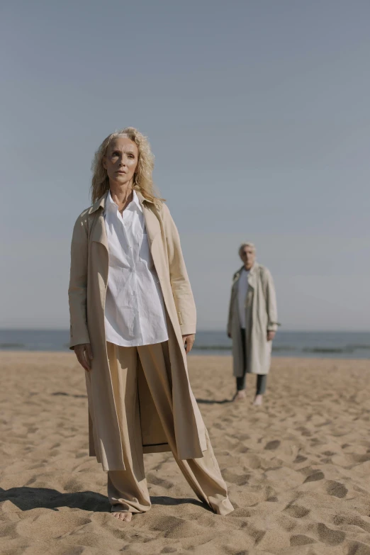 an older couple standing in the sand on a beach