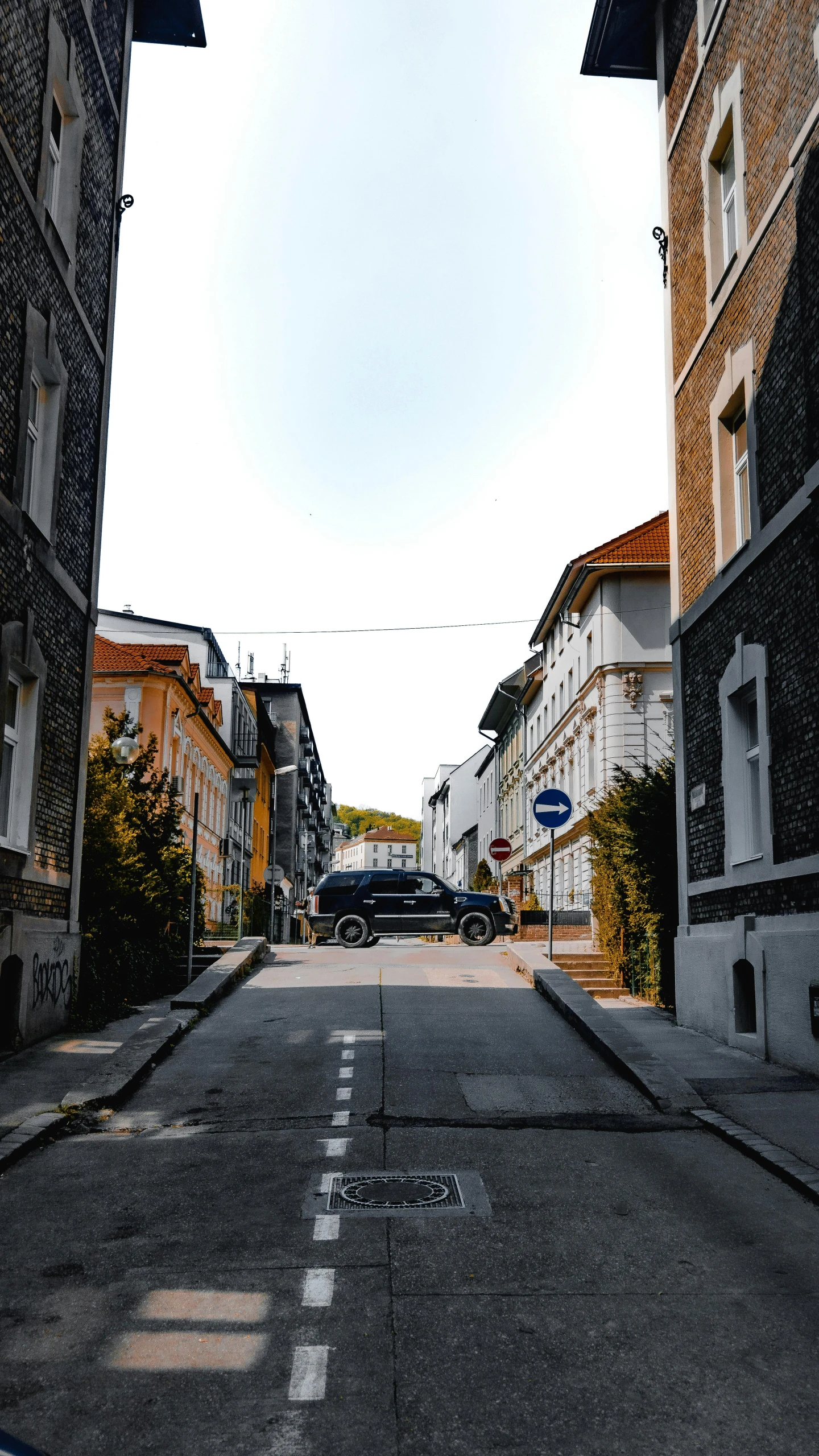 a black car driving through an opening in the road