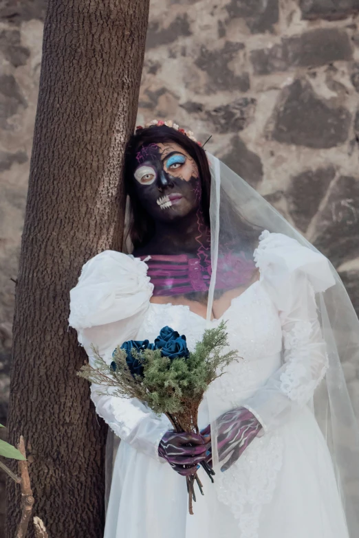 a person in a white wedding dress and a black mask with flowers