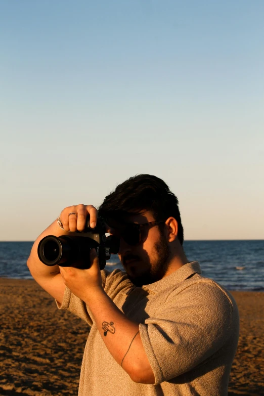 a man takes a po with his camera near the beach