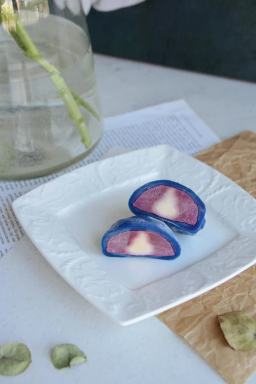 two pieces of purple fruit that have pink petals