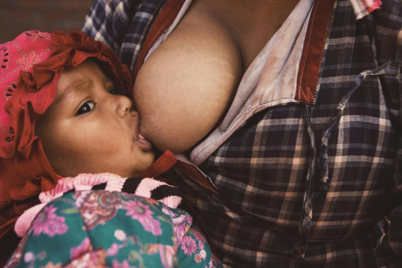 a woman is  feeding her baby a bottle