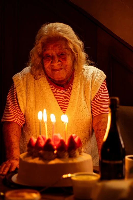 a woman standing in front of a birthday cake with candles
