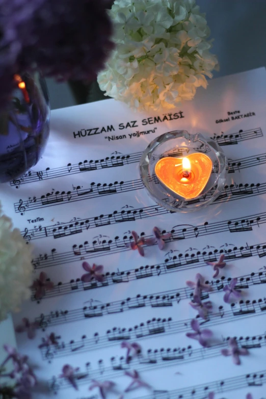 a sheet music with a heart and candle in it