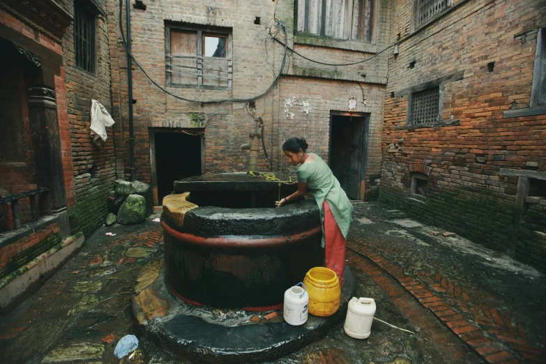 a woman is doing soing on a large barrel