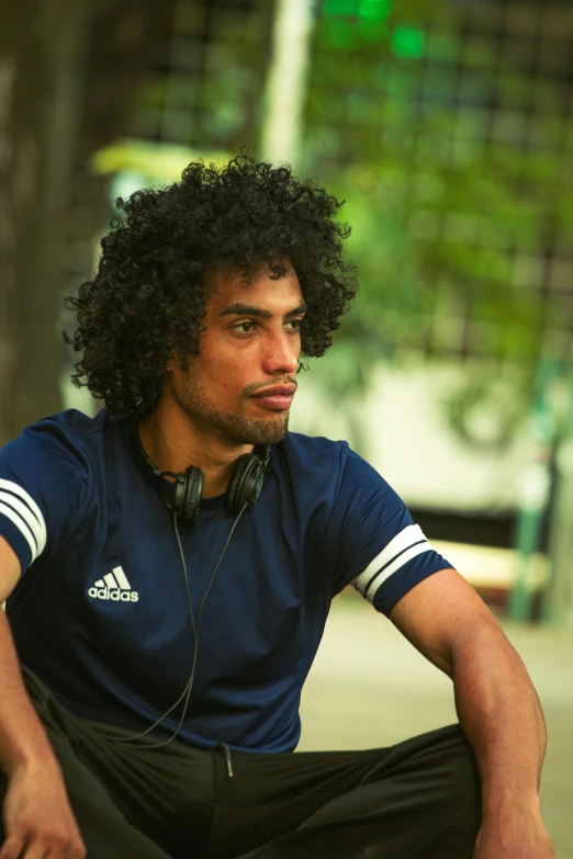 young man with long curly hair wearing headphones