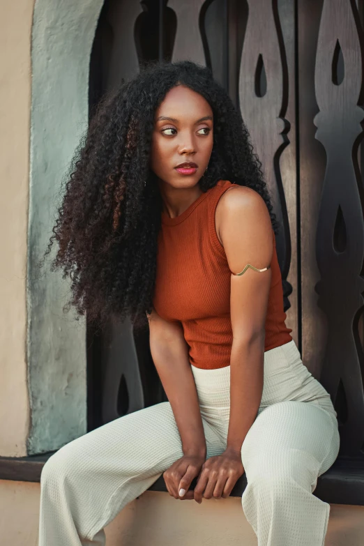 the woman is posing for a po while wearing white pants