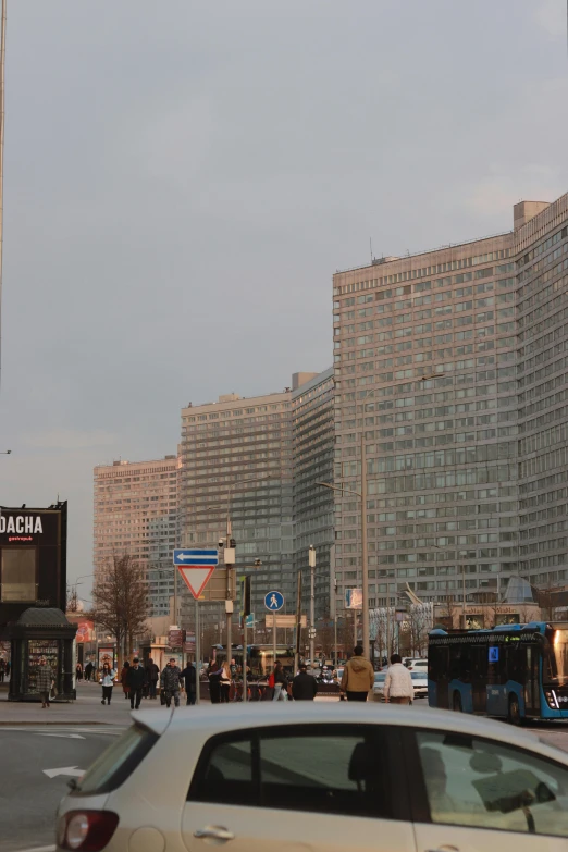 people are walking along a sidewalk next to buildings